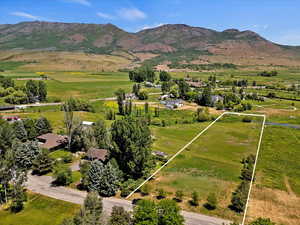 Overview of rural landscape with a mountain backdrop and property parcel outlined