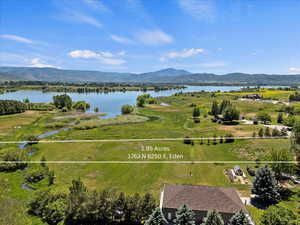 Aerial overview of property's location with a water and mountain view and property parcel outlined