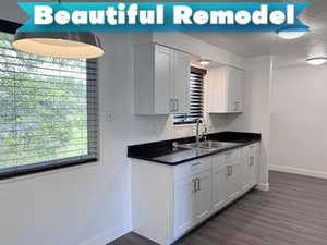 Kitchen with dark countertops, white cabinetry, and dark wood-style floors