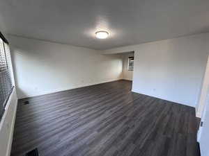 Unfurnished room featuring dark wood-style flooring