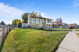 Split foyer home with brick siding, a chimney, an attached garage, and driveway