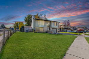 Bi-level home with asphalt driveway, a chimney, an attached garage, and brick siding