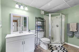 Full bathroom featuring a stall shower, vanity, tile patterned floors, and a paneled ceiling