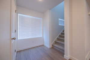 Stairway featuring wood finished floors and baseboard heating