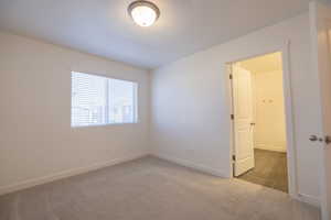 Carpeted empty room featuring baseboards