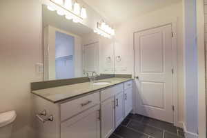 Bathroom with vanity and dark tile patterned floors