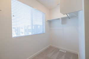 Spacious closet with light colored carpet