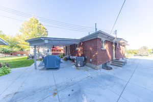 View of side of home featuring a patio area and brick siding