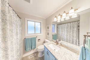Bathroom with vanity, curtained shower, crown molding, and dark wood finished floors
