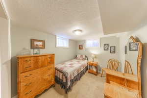 Bedroom with light carpet and a textured ceiling