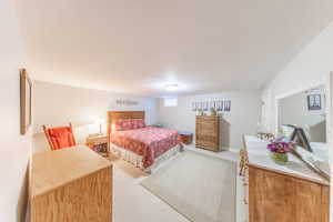 Bedroom with light colored carpet and baseboards