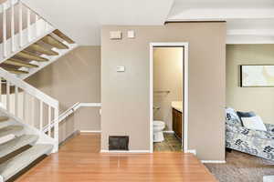 Stairway with wood finished floors and baseboards