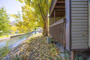 View of property exterior featuring a water view and a central air condition unit