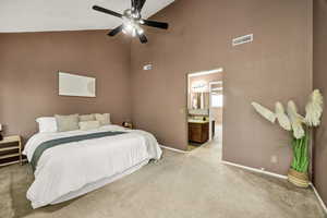 Carpeted bedroom with high vaulted ceiling, a ceiling fan, and connected bathroom