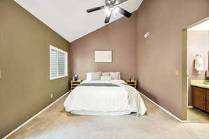 Bedroom featuring light colored carpet, ceiling fan, and high vaulted ceiling
