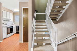 Stairway with a textured wall and wood finished floors