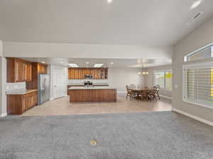 Kitchen with light tile patterned floors, stainless steel appliances, light carpet, and recessed lighting