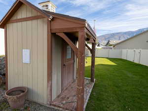 View of outbuilding featuring a fenced backyard and a mountain view