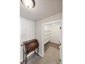 Corridor featuring a textured ceiling and baseboards