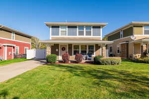 Traditional style home featuring covered porch, a front yard, concrete driveway, and roof with shingles