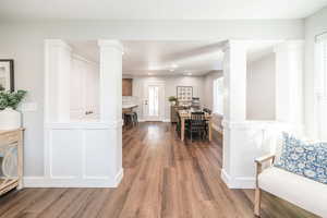Dining room with dark wood-type flooring, plenty of natural light, recessed lighting, and decorative columns
