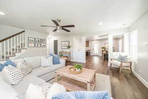 Living area featuring hardwood / wood-style flooring, recessed lighting, stairway, a ceiling fan, and decorative columns