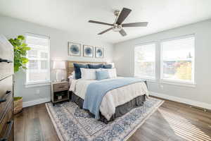 Bedroom featuring multiple windows, dark wood finished floors, and ceiling fan
