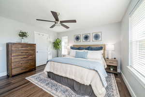 Bedroom with dark wood-style flooring, a ceiling fan, and a closet
