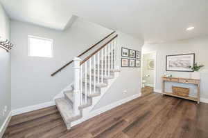 Stairway featuring wood finished floors and recessed lighting