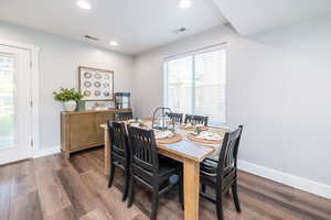 Dining area with dark wood-type flooring and recessed lighting