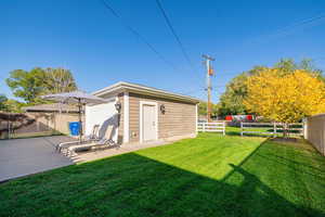 Fenced backyard with an outbuilding and a patio