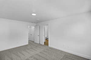 Unfurnished bedroom featuring carpet floors and ensuite bath
