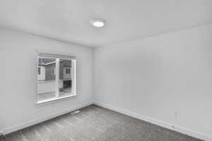 Carpeted empty room featuring baseboards