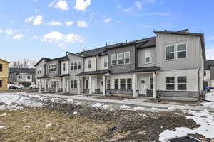 View of front of home featuring board and batten siding, a residential view, stone siding, and a porch