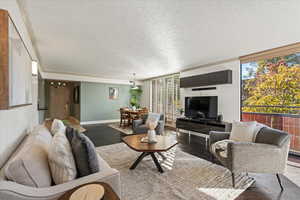 Living room featuring a textured ceiling, wood finished floors, and a wall of windows