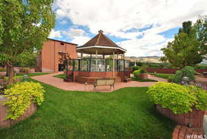 View of grassy yard with a deck, a patio, and a gazebo