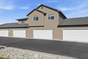 Traditional-style home featuring roof with shingles and driveway