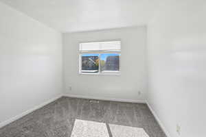 Carpeted spare room with baseboards