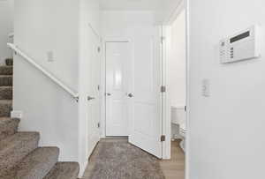 Corridor with stairs and light wood-style flooring