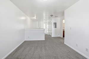 Empty room with carpet floors and electric panel
