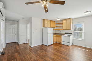 Kitchen with white appliances, light brown cabinets, open shelves, ceiling fan, and dark wood finished floors