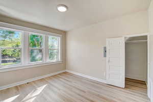 Unfurnished bedroom featuring a walk in closet and light wood-type flooring