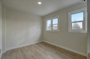 Spare room with healthy amount of natural light, light wood-style flooring, and recessed lighting