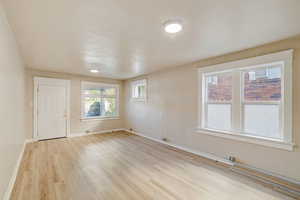 Unfurnished living room with healthy amount of natural light and light wood-type flooring
