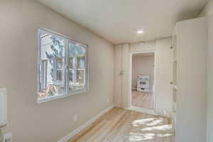 Corridor featuring light wood-type flooring and recessed lighting