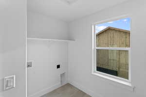 Laundry room featuring hookup for a washing machine and light tile patterned flooring