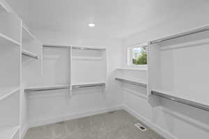 Walk in closet featuring light carpet