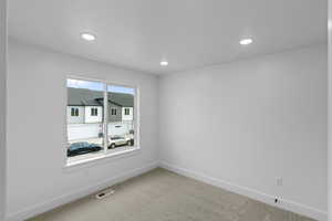 Carpeted empty room with baseboards and recessed lighting