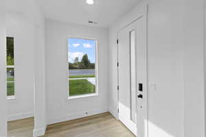 Entryway featuring wood finished floors, recessed lighting, and a water view
