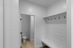 Mudroom with light tile patterned floors and baseboards